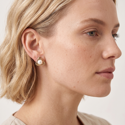 lumina pearl triangle stud earrings in yellow gold finish — model view