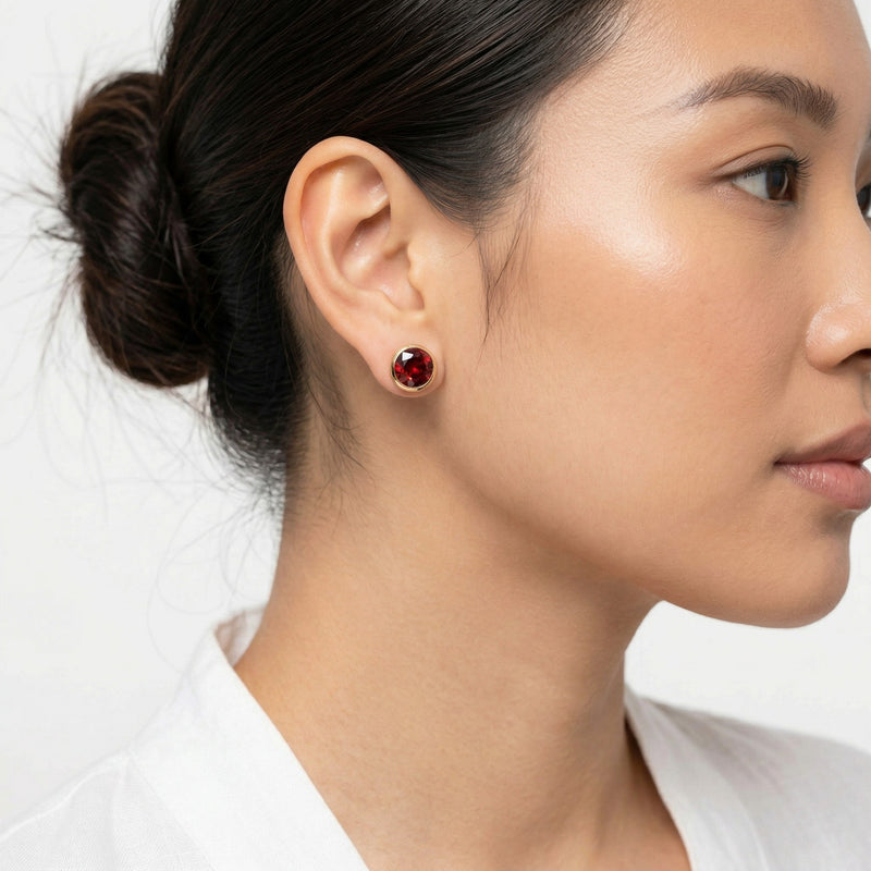 garnet birthstone stud earrings in yellow gold finish — model view
