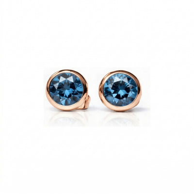 blue topaz birthstone stud earrings in rose gold finish — front view