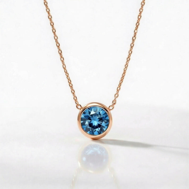 blue topaz birthstone necklace in rose gold finish — front view