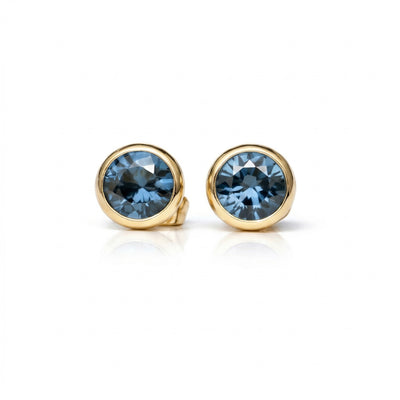 blue topaz birthstone stud earrings in yellow gold finish — front view
