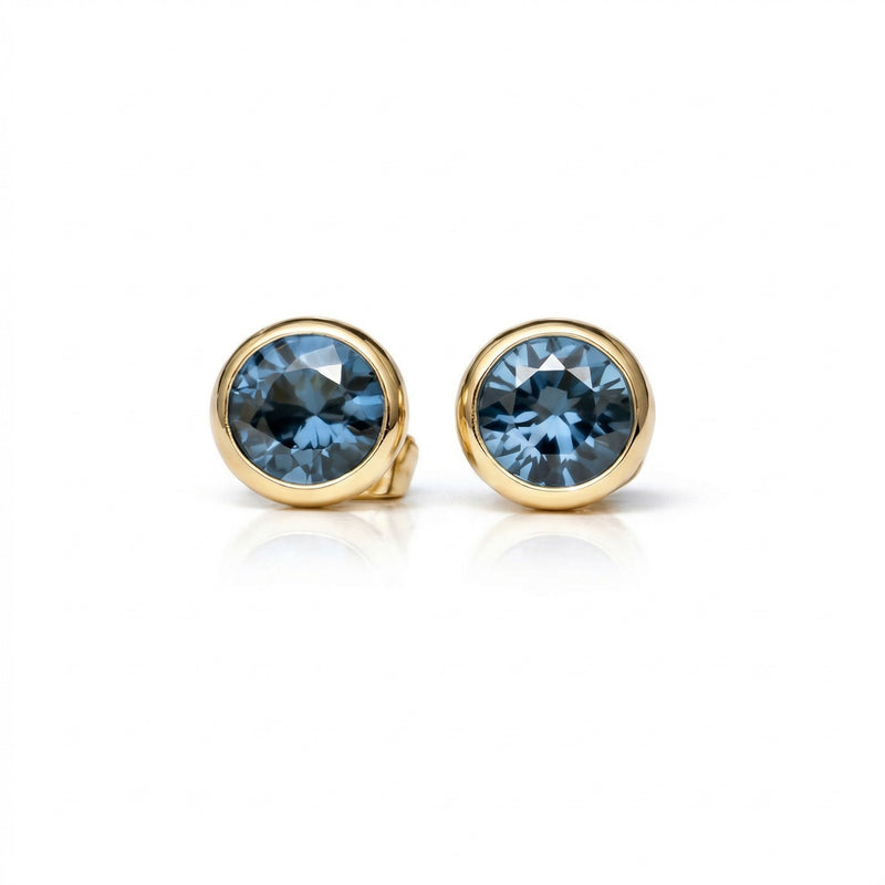 blue topaz birthstone stud earrings in yellow gold finish — front view