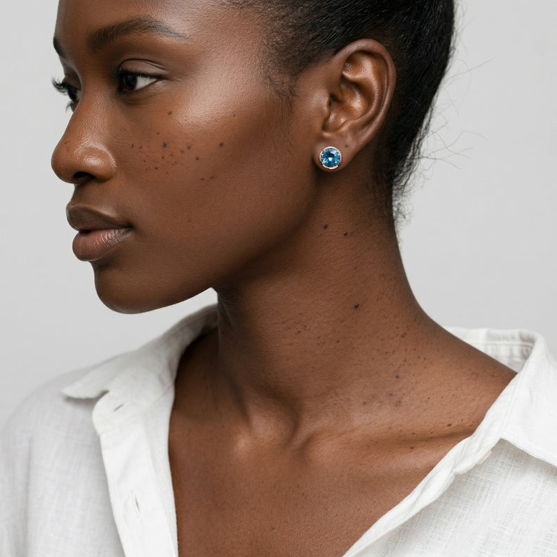 blue topaz birthstone stud earrings in rose gold finish — model view