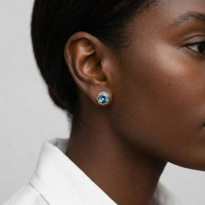 blue topaz birthstone stud earrings in yellow gold finish — model view
