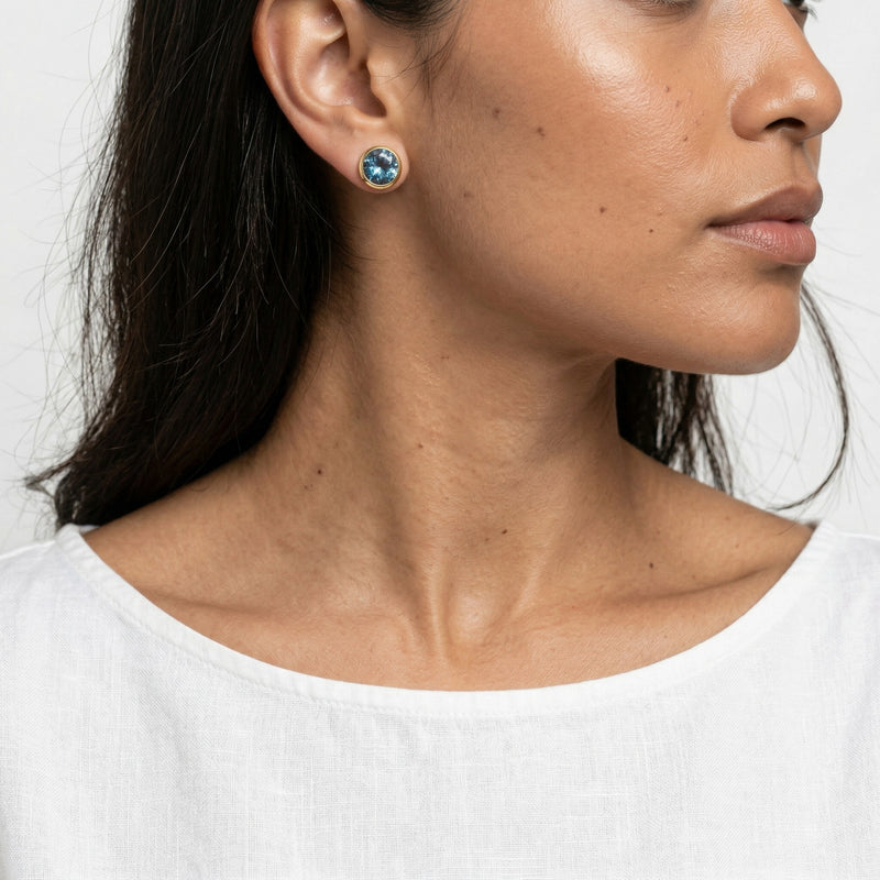 blue topaz birthstone stud earrings in yellow gold finish — model view