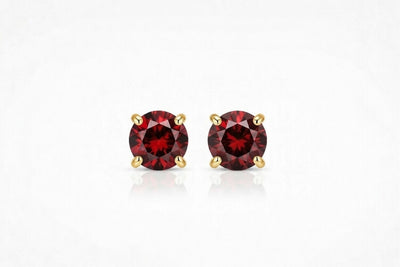 garnet birthstone stud earrings in yellow gold finish — front view