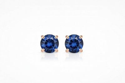 sapphire birthstone stud earrings in rose gold finish — front view