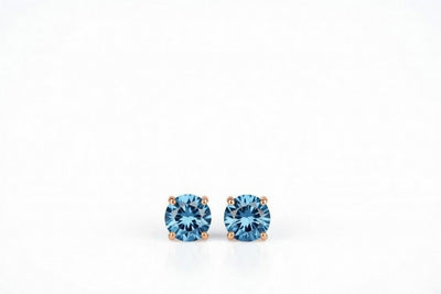 blue topaz birthstone stud earrings in rose gold finish — front view