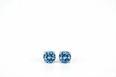blue topaz birthstone stud earrings in white gold finish — front view