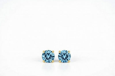 blue topaz birthstone stud earrings in yellow gold finish — front view