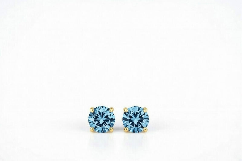 blue topaz birthstone stud earrings in yellow gold finish — front view