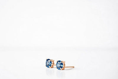 blue topaz birthstone stud earrings in rose gold finish — side view