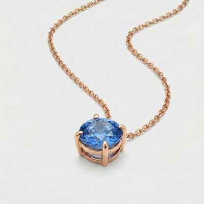 blue topaz birthstone necklace in rose gold finish — side view