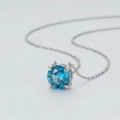 blue topaz birthstone necklace in white gold finish — side view