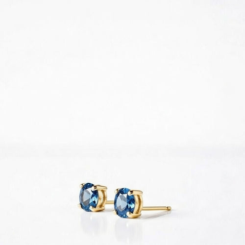 blue topaz birthstone stud earrings in yellow gold finish — side view