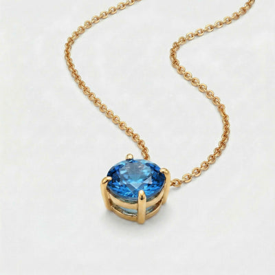 blue topaz birthstone necklace in yellow gold finish — side view
