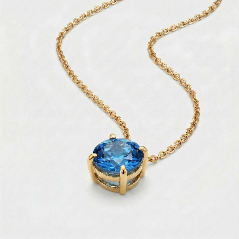 blue topaz birthstone necklace in yellow gold finish — side view